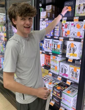 Colby Allen was one of the Student Health Advisory Board members who volunteered to place labels on alcohol sold in local stores May 11 to warn adults about laws covering underage drinking. BILL PEARSON/Boothbay Register