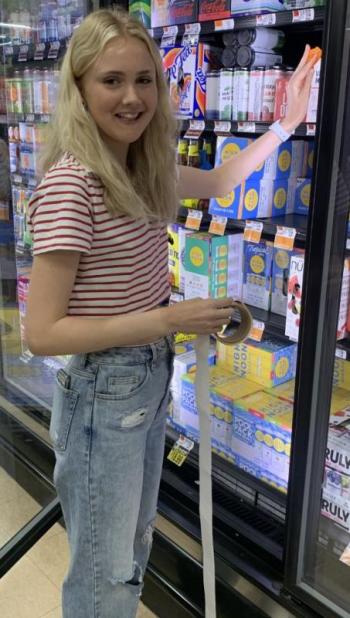 Kate Campbell was one of the Student Health Advisory Board members who volunteered to place labels on alcohol sold in local stores May 11 to warn adults about laws covering underage drinking. BILL PEARSON/Boothbay Register