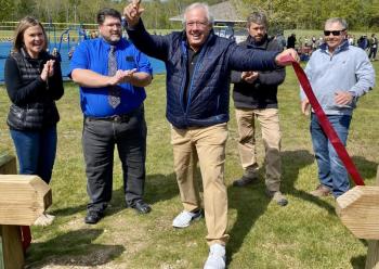 Local philanthropist Paul Coulombe cuts the ribbon May 26 during the ceremony for the new Little League baseball field’s opening. Michelle Amero photo