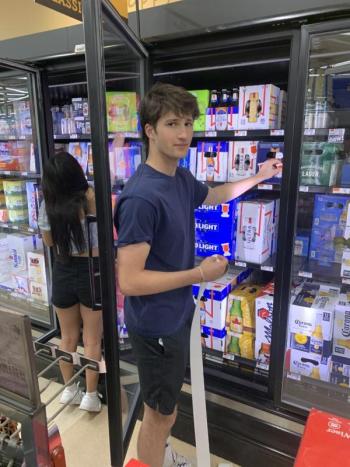 Gryffin Kristan was one of the Student Health Advisory Board members who volunteered to place labels on alcohol sold in local stores May 11 to warn adults about laws covering underage drinking. BILL PEARSON/Boothbay Register