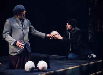 A gravedigger (Tim Cunningham) hands Hamlet (Thomas Daniels) the skull of his father’s jester Yorick, whom Hamlet loved. Courtesy of Heartwood