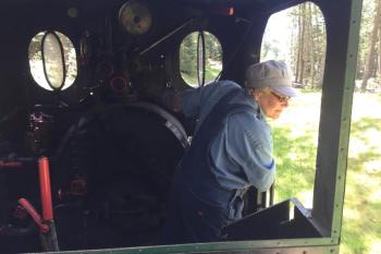 Cathy Orne watches the train as she drives it along the railway village track. FRITZ FREUDENBERGER/Boothbay register