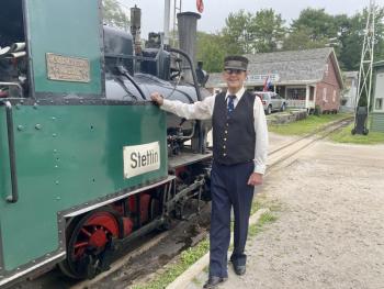 Roberto Forrest, volunteer conductor and engineer, poses with the museum’s famous 1934 train. ISABELLE CURTIS/Boothbay Register