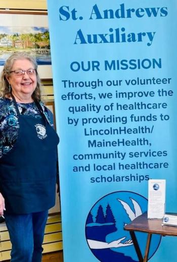 Auxiliary member Pam Reed with new Auxiliary Mission Statement Banner. Courtesy photo