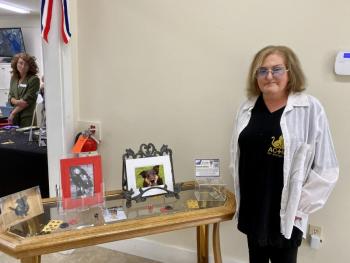 Giselle Armstrong, founder of Action for Animals Maine (AFAM), poses with photos of Butterball, the dog who inspired her to create the organization. ISABELLE CURTIS/Boothbay Register