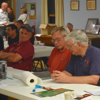 David Pratt, Richard Spofford and Paul Mayotte look over one of Spofford’s awards. FRITZ FREUDENBERGER/Boothbay Register