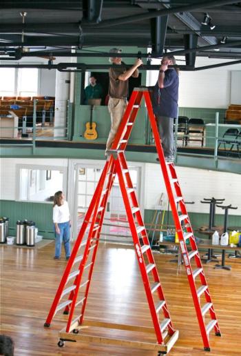Steve Malcom and Mark Stover hang lights for the 2003 Jackson Browne benefit concert. Cathy Sherrill supervises from below. File photo