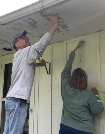John and Lisa Dingle scrape paint Sept. 23 as part of a home improvement project performed by Rebuilding Together Lincoln County volunteers in Boothbay. BILL PEARSON/Boothbay Register