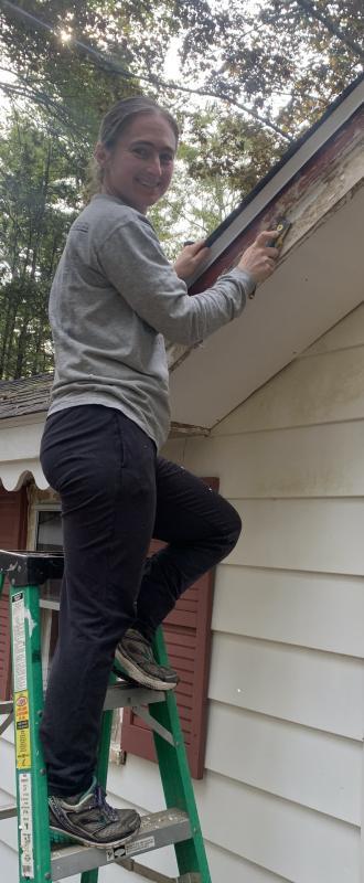 Laura Sofen of Boothbay Harbor grabbed a paint scraper and brush to assist with an Old Trevett Road house painting job Sept. 23 as part of Rebuilding Together Lincoln County’s volunteer project. BILL PEARSON/Boothbay Register