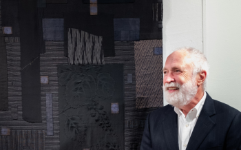 Textile artist Michael Olszewski is shown with his fabric collage at the opening of the Maine Art Gallery's current show, "The Artful Interior." Bob Bond photo Textile artist Michael Olszewski