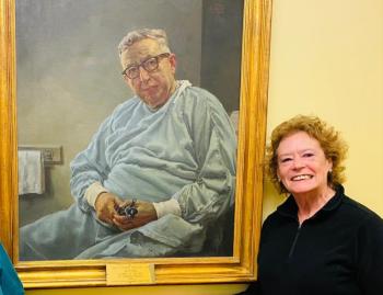 Auxiliary member Sarah Giles beside the portrait of her father-in-law, Dr. Phillip Gregory. Courtesy photo
