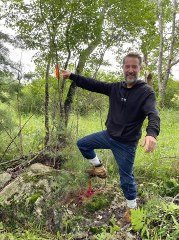 Chris Coombs points to a marker at the corner of the Bristol conservation easement he and his wife Natalie recently donated. Courtesy of Coastal Rivers