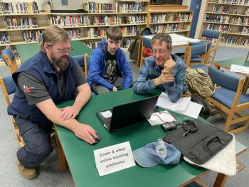 Brandon Look, a digital planner with Coastal Maine Regional Broadband , left, and BRHS student Cole Hyson, help a community member move content from an old device to a new one. Courtesy of Raye Leonard