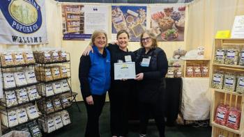 Julie Roberts, center, owner of Coastal Maine Popcorn holds her award. Courtesy of Cherie Scott