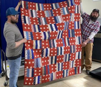Fuller Marine employees display a quilt made for Christopher George, a veteran. He was guest of honor at a May 4 benefit breakfast. BILL PEARSON/Boothbay Register