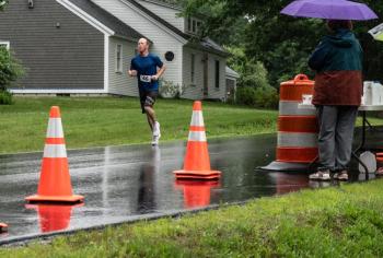D.J. Kelly passes an aid station on his way to take the top prize for the 5K leg of the Edgecomb 250th Birthday Road Race on June 22. Volunteers helped man three aid stations along the course to provide water and assistance as needed. Bisi Cameron Yee photo