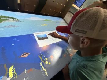 This youngster was one of the 630 people who visited the Research Touch Table at the new Gulf of Maine Discovery Center grand opening on June 26. LISA KRISTOFF/Boothbay Register