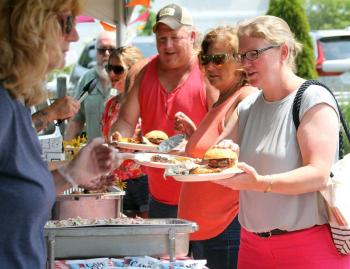 Mike Alley, left, Becky Alley and Maddie Kaler pick up their food at the barbecue. STEVE EDWARDS/Boothbay Register