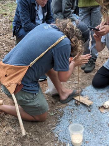 Josh Leatham demonstrates fire-starting by bow drilling. CANDI JONETH/Boothbay Register Event