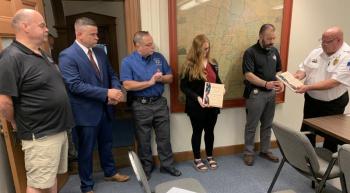 Boothbay Region Ambulance Service Director Dan Gardner officially thanks Lincoln County first responders Aug. 20 for their assistance in saving a 5-year-old boy’s life last month. Pictured, from right, Gardner, Sgt. Scott Hayden, Rhiannon Hersey, dispatcher; Mark Fortin, deputy; Det. Jared Mitkus, LCSO; and Rob Bickford, communications deputy director. BILL PEARSON/Boothbay Register