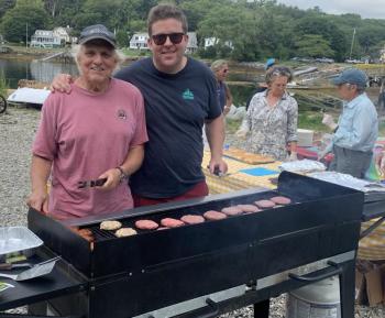 Grill masters Chris Richardson, left, and Denny Whitten cooked burgers and hot dogs Aug. 16 at Boothbay Sea and Science Center “Last Day of Camp” barbecue. .BILL PEARSON/Boothbay Register