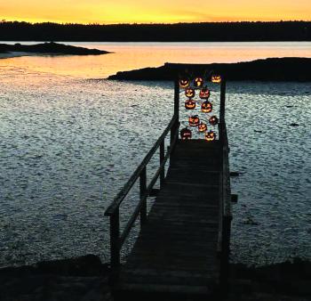 Carved pumpkins lit up at sunset. 