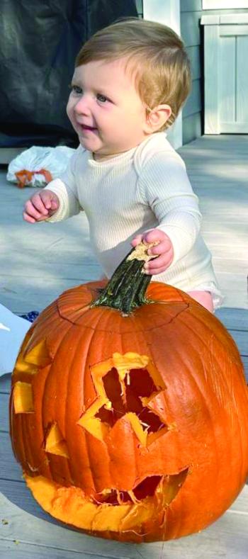 A child and a pumpkin