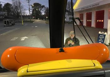 A man taking pictures of the Wienermobile