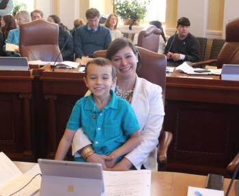 Sen. Cameron Reny with her son, George, at her desk in the Senate Chamber moments before Sen. Reny was sworn in for her second term in the Maine Senate. Courtesy photo