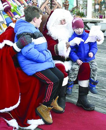 Jonah Curtz, right, shows Santa his drawing of a motorcycle as his brother, Theo, watches. FRITZ FREUDENBERGER/Boothbay Register
