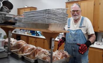 Ed Harmon brings turkeys out of the oven on Wednesday morning in preparation for the free community Thanksgiving feast at the Charles E. Sherman American Legion hall. JANE CARPENTER/Boothbay Register Ed Harmon