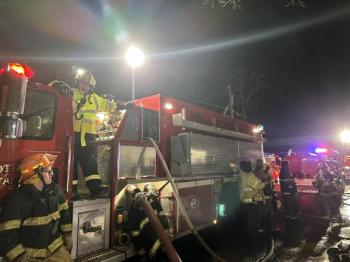 Firefighter Lucian Laurie (yellow jacket, on Tank 2) runs water supply operations and feeding water from Tank 2 to Engine 2. Courtesy of Mark Sullivan Firefighter Lucian Laurie (Yellow jacket, on Tank 2) running water supply operations and feeding water from Tank 2 to Engine 2. Courtesy of Mark Sullivan