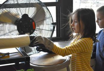 BRES first graders try their hand at reshaping recycled plastic with artist Kim Bernard's extruder. ISABELLE CURTIS/Boothbay Register