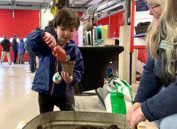 A young attendee pots flower seeds at Coastal Maine Botanical Gardens’ booth at Earth Day Fest. ISABELLE CURTIS/Boothbay Register