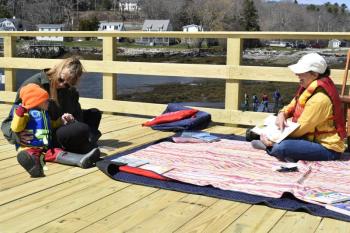 BHML Children’s Coordinator.Jen Betts hosted a reading station on the sea and science center's new pier. FRITZ FREUDENBERGER/Boothbay Register