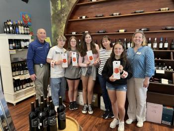 Boothbay Region High School students, School Resource Officer Larry Brown, and HLC's MaryElizabeth Filon are welcomed by Cathy Pinkham to bring Sticker Shock to to Pinkham's Gourmet Market. Courtesy photo BRHS students
