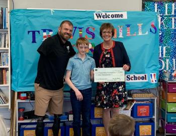 6th grader Duncan Scott helps present the ceremonial check to his chosen charity, the Travis Mills Foundation. Pictured: Travis Mills, Duncan Scott, and principal Lisa Clarke. ISABELLE CURTIS/Boothbay Register 6th grader Duncan Scott helps present the ceremonial check to his chosen charity, the Travis Mills Foundation. Pictured: Travis Mills, Duncan Scott, and principal Lisa Clarke. ISABELLE CURTIS/Boothbay Register