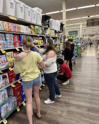 WMHS YSUP team members Raegan Eddy, Gabby Dotson, Jordan Saylor, Sienna Hogan, and Olivia Whittaker sticker alcohol products at Shaw's in Wiscasset. Courtesy photo YSUP students