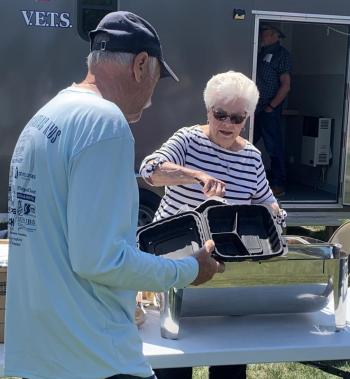 Volunteer Sue Burge serves hungry guests Aug. 2 during the Boothbay V.E.T.S. fundraiser. BILL PEARSON/Boothbay Register sue burge