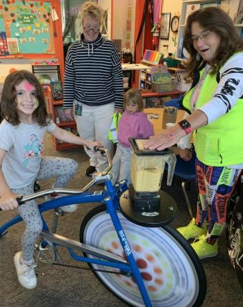 Southport Central School student Giavanna Cartonia pedals the bicycle-powered blender Oct. 2 which made smoothies for Rock Your School Day. Also pictured, Kim Burnham, Kiana Lee and Eileen Higgins. BILL PEARSON/Boothbay Register smoothie ride