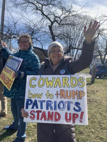 Alna's Sherry Lyons waves to motorists during a pro-federal funding for libraries rally April 10 at the bottom of Wiscasset Common. SUSAN JOHNS/Wiscasset Newspaper