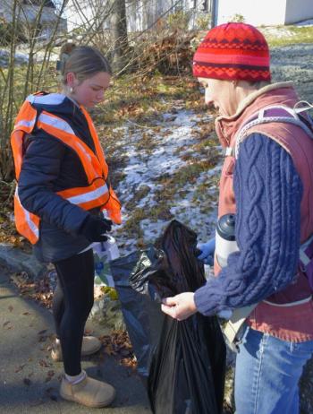 Maddie Andreasen, left, disposes of trash with the help of teacher Emily Higgins. FRITZ FREUDENBERGER/Boothbay Register 