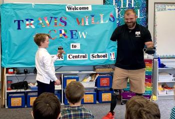 Travis Mills shows off his prosthetic's detachable hand function with the help of a Southport student. ISABELLE CURTIS/Boothbay Register