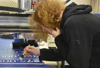 Liam Scott paints the newly engraved numbers. ISABELLE CURTIS/Boothbay Register