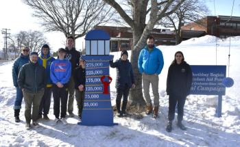 After much shoveling, nailing and adjusting, the Boothbay Region Student Aid Fund's new sign is installed on the high school lawn Feb. 4. Pictured:  Sarah Baldwin, Chip Schwehm, Zander Blake, Nathan Percival, Harry Hinkley, Abby Orchard, Hildy Johnson, Chris Liberti and Preston Giles. Not pictured: Brandon Seigars, Mathew Jackson, Spencer Wood and Cameron Lewis. 