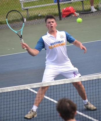 Ronan Drage, playing first doubles with Harry Hinckley, watches his drop shot at the net against North Yarmouth Academy May 19. KEVIN BURNHAM/Boothbay Register