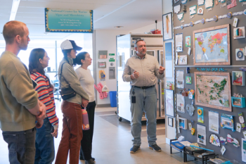 Senior Research Scientist Mike Lomas shows WWF colleagues a display that spotlights the history, reach, and impact of the NCMA (Credit: Alex Seise)
