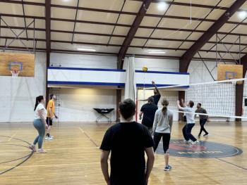 Volleyball players stand ready as their teammate hits the ball. Photo by Trevor Tibbetts
