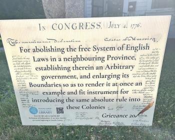 This is one of the many signs being posted at area businesses and organizations for the library’s Grievance Walking Tour. Each banner includes a QR code connecting visitors to additional resources encouraging participants to explore the Declaration while discovering the community. Staff photo