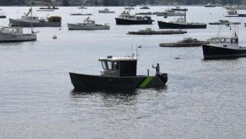 A volunteer showcases how a personal flotation device would deploy if a person fell overboard.  ISABELLE CURTIS/Boothbay Register